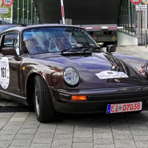Vintage brown Porsche car at an automotive event in the city