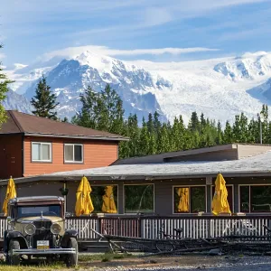 Vintage car and historic building in front of mountain landscape with Kennicott Glacier Vintage car and historic building in front of mountain landscape with Kennicott Glacier