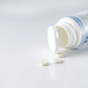 Vitamins for cats and dogs falling out of a white plastic jar Vitamins for cats and dogs falling out of a white plastic jar