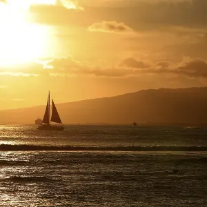 Waikiki with a sailboat in front of the mountains at sunset Waikiki with a sailboat in front of the mountains at sunset