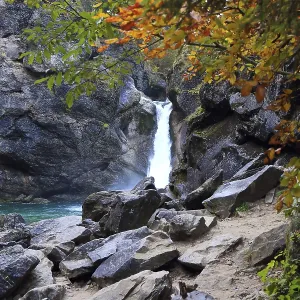 Cascada rodeada de rocas y árboles de otoño. Cascada rodeada de rocas y árboles de otoño.