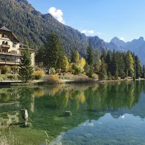 Waterfront villa on a clear mountain lake reflected against rugged peaks