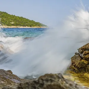 Wellen brechen an einem Felsen im Meer an einem sonnigen Tag auf der Insel Cres. Wellen brechen an einem Felsen im Meer an einem sonnigen Tag auf der Insel Cres.