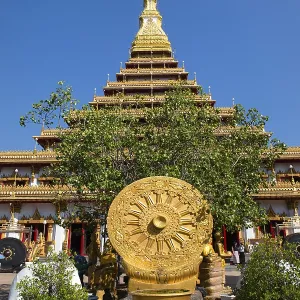 Wheel of Life in front of a nine-story Stupa Phra Mahathat Kaen Kakhon Wheel of Life in front of a nine-story Stupa Phra Mahathat Kaen Kakhon