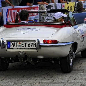 White convertible classic car in a series of classics seen from behind