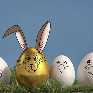 Three white eggs with painted chicken faces chicks and one golden egg with a painted rabbit face Three white eggs with painted chicken faces chicks and one golden egg with a painted rabbit face