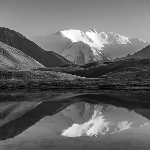White glaciated and snowy mountain peak Lenin Peak at sunset White glaciated and snowy mountain peak Lenin Peak at sunset