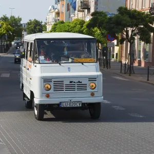 White minibus in an urban environment on a busy street White minibus in an urban environment on a busy street