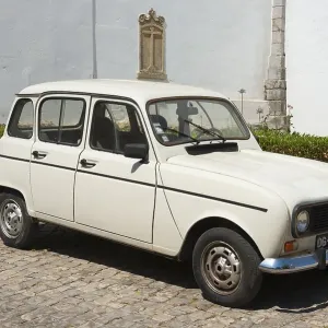 White vintage car on cobblestones in front of a historic building White vintage car on cobblestones in front of a historic building