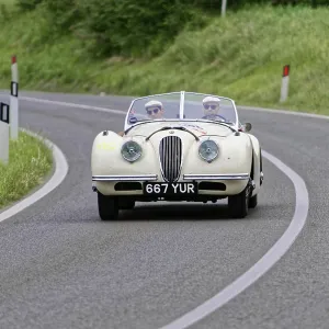 White vintage convertible on a winding country road surrounded by nature White vintage convertible on a winding country road surrounded by nature