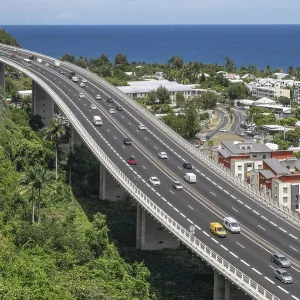Wide, modern viaduct of the national road RN1 and part of the Route des Tamarins with lively traffic (cars and lorries) Wide, modern viaduct of the national road RN1 and part of the Route des Tamarins with lively traffic (cars and lorries)