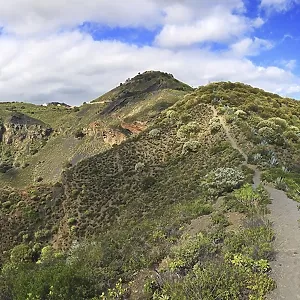 Vue large de la cratère Bandama avec les montagnes environnantes sous un ciel nuageux, Grande Canarie, Espagne.