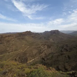 Wide view of a dry, rocky mountain landscape under clear sky Wide view of a dry, rocky mountain landscape under clear sky