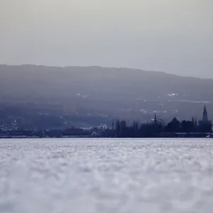 Wide view of lake and mountains at twilight in winter
