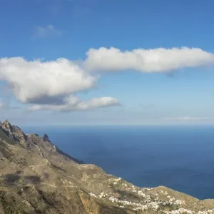 Wide view over mountains to the deep blue sea under a sky with scattered clouds Wide view over mountains to the deep blue sea under a sky with scattered clouds
