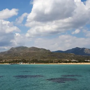 A wide view over the sea with mountains and clouds in the background A wide view over the sea with mountains and clouds in the background