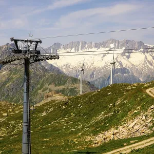 Wind Turbine and Mountain with Glacier in the Swiss Alps and Overhead Cable Car and Blue Sky