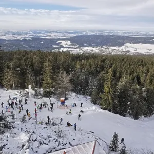 Winter landscape with snow-covered forest and people skiing Winter landscape with snow-covered forest and people skiing