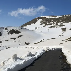 Winter landscape with snow-covered mountains and a paved road