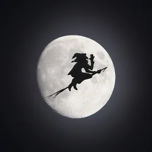 Witch as weather vane, silhouette in front of full mooen