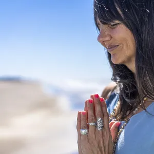 Frau in einem blauen Tanktop genießt einen Moment der Ruhe am Strand. Frau in einem blauen Tanktop genießt einen Moment der Ruhe am Strand.