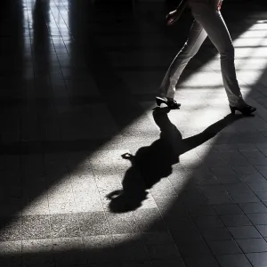Woman casting a shadow on the floor of a building