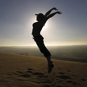 Woman leaping into the air in the desert