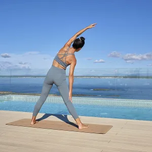 Eine Frau übt Yoga auf einem Dach mit atemberaubender Meeresansicht. Eine Frau übt Yoga auf einem Dach mit atemberaubender Meeresansicht.