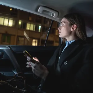 Woman traveling as a passenger in a ride hailing car at night Woman traveling as a passenger in a ride hailing car at night