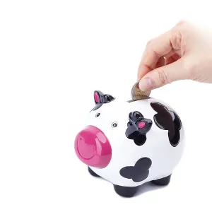 Woman's hand putting a coin in piggy bank<br> Woman's hand putting a coin in piggy bank