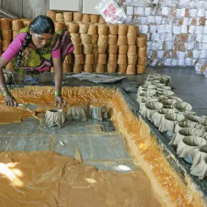 Women putting jaggery in moulds Women putting jaggery in moulds