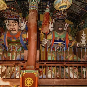 Wood carved statues of two Buddhist deities in covered pavilion at temple Wood carved statues of two Buddhist deities in covered pavilion at temple