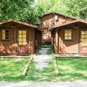 Wooden bungalows on campsite camping. Green trees