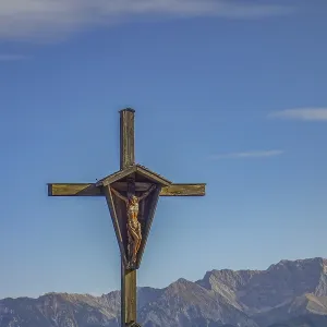 Wooden cross in front of mountain landscape under clear sky Wooden cross in front of mountain landscape under clear sky