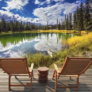 Two wooden deckchairs for tourists on ashore shallow round lake Two wooden deckchairs for tourists on ashore shallow round lake