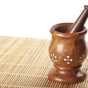 Wooden mortar with pestle on bamboo mat Wooden mortar with pestle on bamboo mat