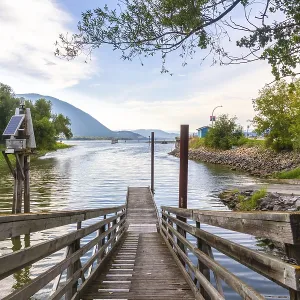 Wooden pier with solar powered navigation light extending into shuswap lake in salmon arm Wooden pier with solar powered navigation light extending into shuswap lake in salmon arm