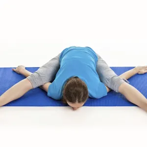 Yoga, young beautiful slender woman yoga instructor doing Tortoise Pose (Kurmasana)