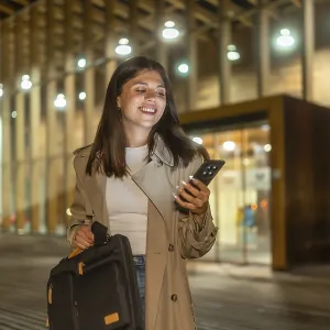 Young businesswoman smiling while checking her smartphone Young businesswoman smiling while checking her smartphone