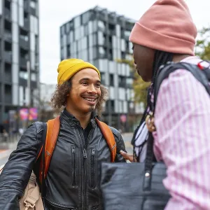 Young diverse friends smiling and chatting on a city street