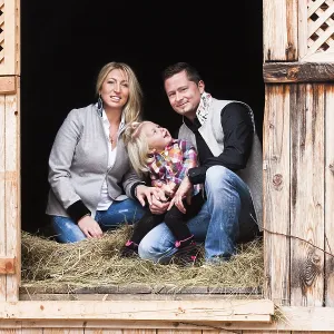 Young family sitting in the hay barn