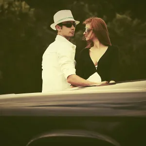 Young fashion couple in love next to vintage car