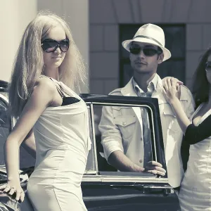 Young fashion people next to vintage car in city street