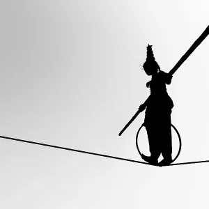 Young girl balancing a on rope in silhouette Young girl balancing a on rope in silhouette