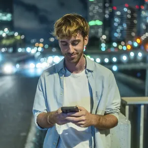 Young man standing on a city bridge at night Young man standing on a city bridge at night