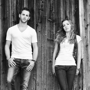 Young man and a young woman leaning against wooden wall Young man and a young woman leaning against wooden wall