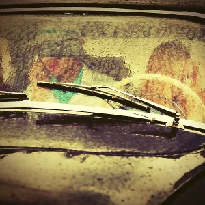 Young people driving vintage car in the rain