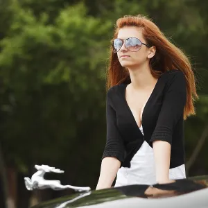 Young woman by the classic car