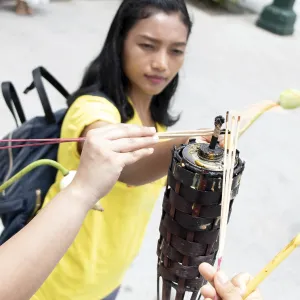 A young woman ignite stick in the Buddhist temple at Buddhist holiday Visakha (Vesak) Bucha day