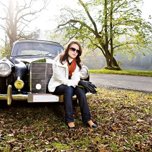 Young woman in front of a post-war classic car